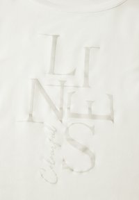 Witte katoenen t-shirt met grote, subtiele grijze typografie met elkaar overlappende letters en het woord "Colourful" in een delicate schrijfaccent.