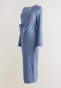 Ribbed, long-sleeve dress in soft blue fabric. Features a v-neck and matching tied waist accent. Designed for a fitted silhouette around the belly.