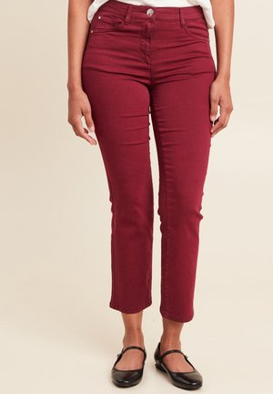 Bordeaux skinny jeans van denim. Middenhoogte taille met vijf-pocket ontwerp en gestikte details. Draag met zwarte flats.