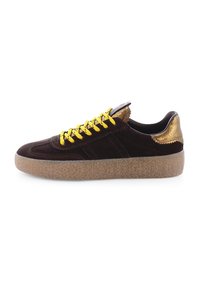 Brown suede sneaker with yellow laces, textured gold accents on heel, and a light brown rubber sole featuring a distinct pattern.