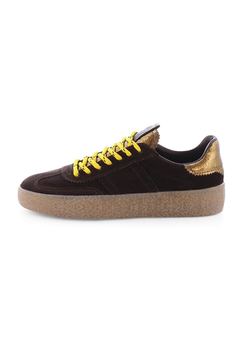 Brown suede sneaker with yellow laces, textured gold accents on heel, and a light brown rubber sole featuring a distinct pattern.
