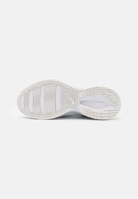 White sneaker sole featuring textured rubber with a grid pattern and smooth accents. Lightweight and designed for grip and flexibility.