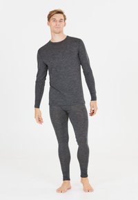 Grå långärmad termaltröja och matchande leggings, tillverkade av ett strukturerat, elastiskt tyg, designade för värme och komfort.