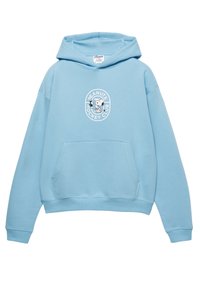Lyseblå pullover-hoodie lavet af blødt stof, med en forlommer og en cirkulær hvid grafik af Snoopy, der spiller hockey.