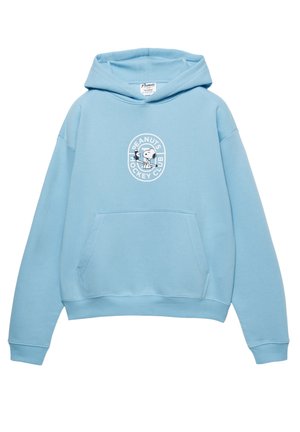 Sweat à capuche bleu clair en tissu doux, avec une poche ventrale et un motif circulaire blanc représentant Snoopy jouant au hockey.