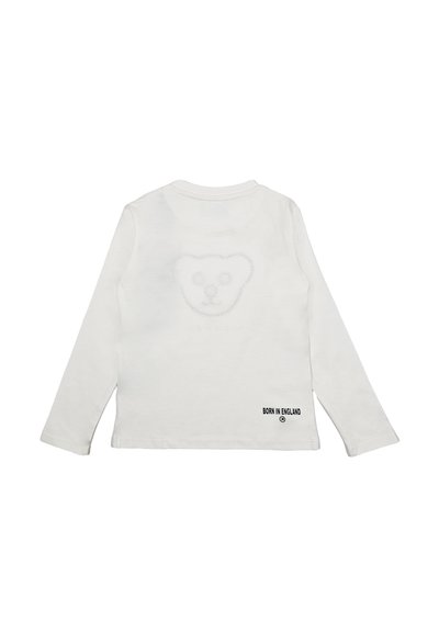 Maglietta bianca a maniche lunghe con un design testurizzato a forma di testa d'orso sul retro e etichetta "NATO IN INGHILTERRAA" in basso a sinistra.