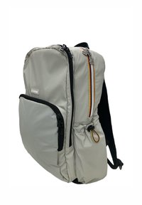 Zaino grigio con accenti neri, multiple tasche con cerniera e un tessuto testurizzato. Presenta dettagli colorati sulla cerniera e spallacci regolabili.