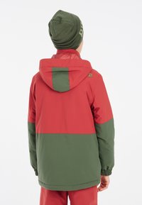 Rot-grün colorblocked Jacke mit Kapuze, featuring elastische Bündchen und einen abgerundeten Saum. Der Stoff wirkt glatt mit einer matten Oberfläche.