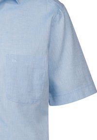 Camicia light blue a maniche corte realizzata in tessuto testurizzato, con taschino sul petto e un discreto logo sulla tasca. Finitura liscia.