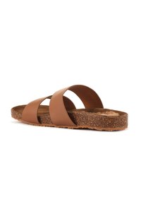 Brown slide sandal with two wide, curved straps. Cork insole with a textured surface. Rubber outsole with a patterned tread for grip.