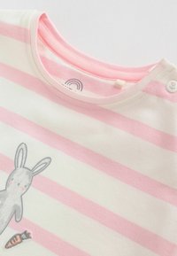 Chemise pour bébé à manches longues rayée rose et blanche, imprimé lapin et carotte, avec un bouton-pression floral près de l'épaule.