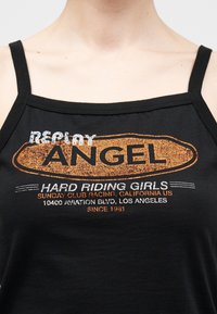 Μαύρο τοπάκι με κείμενο: "Replay Angel, Hard Riding Girls, Sunday Club Racing, California ΗΠΑ, 10400 Aviation Blvd, Λος Άντζελες, Από το 1981."
