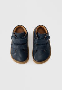 Παιδικά παπούτσια από μπλε δέρμα με δύο λουριά βέλκρο, καφέ εσωτερική επένδυση και υφασμένο λαστιχένιο πέλμα. �Στρογγυλερή μύτη και χαμηλό σχέδιο.