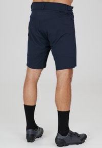 Marineblaue Sportshorts aus leichtem Material mit passgenauer Passform, ausgestattet mit einem markierten Bund und flach genähten Nähten für Haltbarkeit.