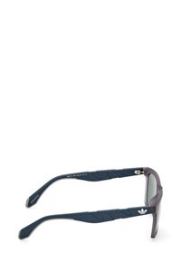 Occhiali da sole con lenti grigie sfumate, montatura blu scuro con bracci texturizzati, accentuazione del logo sulla tempia e una forma sportiva.