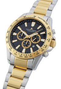 Kronografur med sort urskive, guldtonet bezel og sølv-guld metalarmbånd. Funktioner inkluderer tre sub-dials og lysende markeringer.