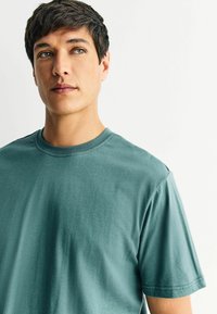 Ti-shirt puuvillane, mille värv on tükka, ümmargune krae, lühikesed varrukad ja pehme tekstuur. Lihtne disain, ilma mustrite või lisakoodideta.