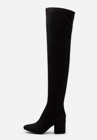 Botas negras de ante por encima de la rodilla con tacón cuadrado y punta afilada, que cuentan con un eje ajustado y un diseño minimalista.