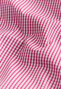 Tissu vichy rouge et blanc à surface texturée, avec de petits carreaux disposés en rangées. Matière douce et légère.