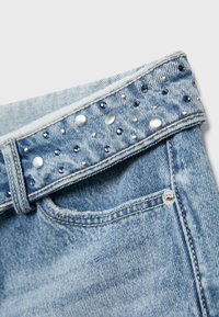 Ceinture de jean en denim bleu clair avec des clous argentés et bleu foncé et de petites strass disposés de manière éparse.
