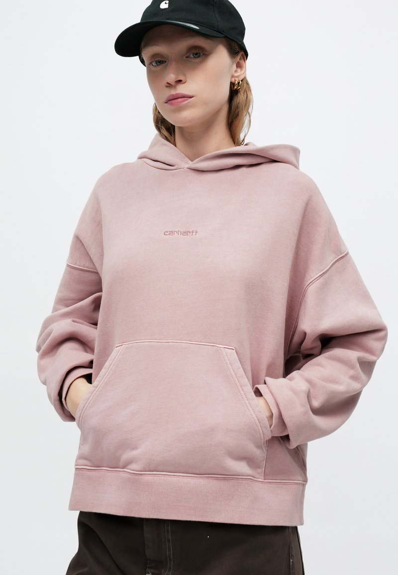 Rosa Kapuzenpullover mit lässigem Schnitt, großer Fronttasche und gerippten Bündchen. Mit einem dezenten Logo, das auf der Brust gestickt ist.