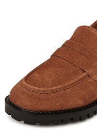 Hnedé semišové loafre s hladkým povrchom, s vyšitým pásom a čiernou gumovou podrážkou s protišmykovými drážkami.