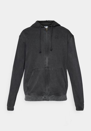 Schwarze Zip-Hoodie mit Kapuze, zwei Fronttaschen, Kordelzug-Verschlüssen und einem dezenten Logo auf der Brust; aus weichem Stoff mit strukturierter Oberfläche.