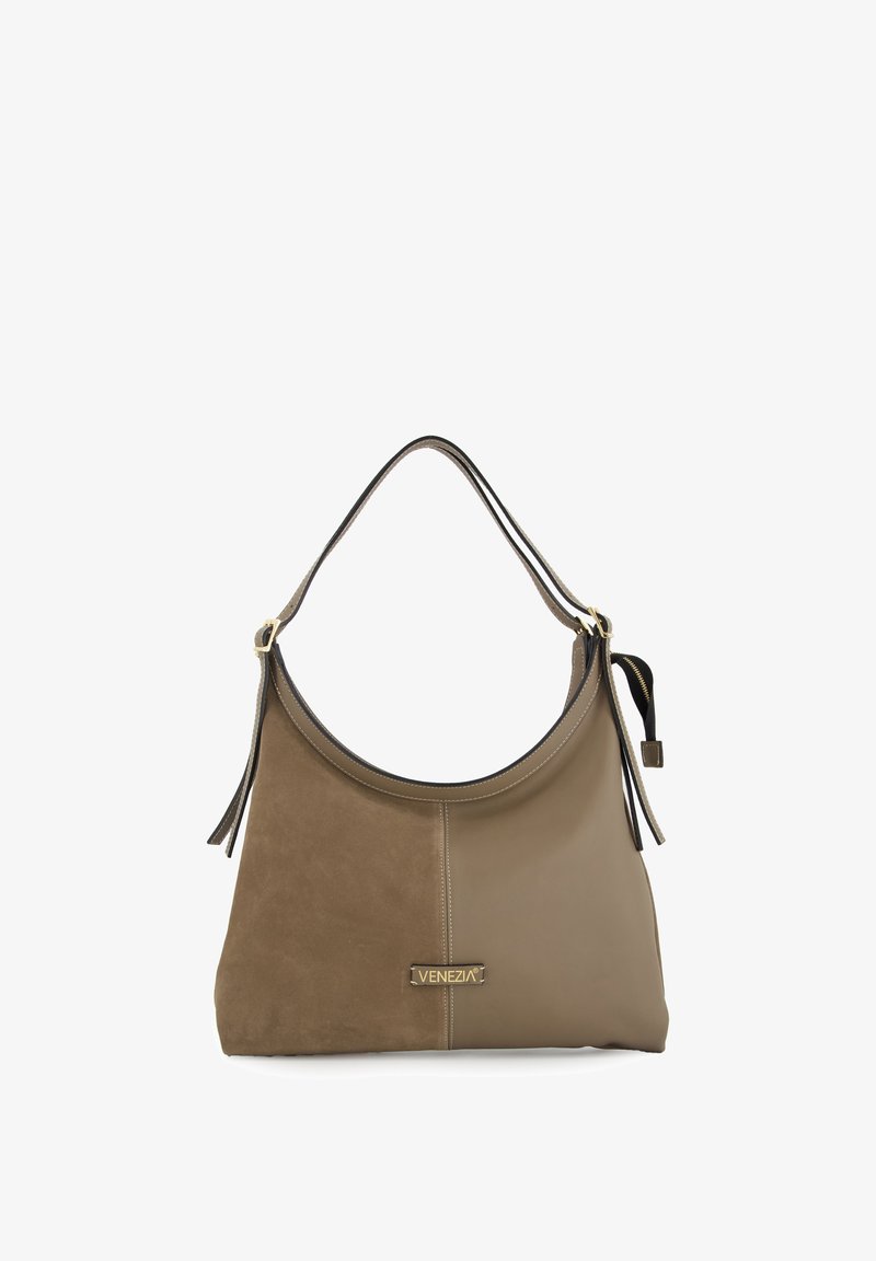 Brown suede and leather shoulder bag with a curved top, featuring a gold logo, detachable tassel, and contrasting fabric panels.