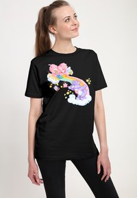 Černé tričko s barevným grafickým potiskem karikaturních medvědů hrajících si na duze, obklopených oblaky a hvězdami. Krátké rukávy, volný střih.