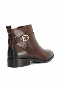 Brown leather ankle boot with a rounded toe, side buckle accent, smooth texture, and a low block heel. Features a slight shine.