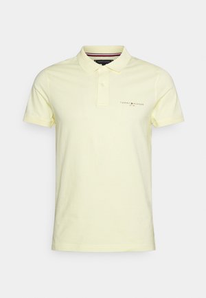 Lichtgele polo met korte mouwen, voorzien van een knoopsluiting met twee knopen en een klein Tommy Hilfiger-logo op de linkerborst.