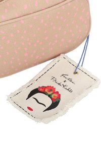 Bolsa beige con manchas rosas, que presenta un tejido texturizado. La etiqueta adjunta muestra un rostro con una diadema floral, etiquetada como "Fritzi x Frida Kahlo."