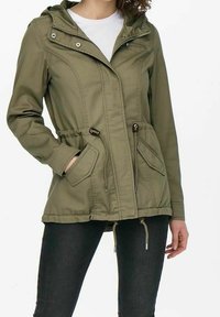Olivgrön jacka med huva, zip-front och två sidofickor. Har justerbar dragsko i midjan och tryckknappar på kragen.