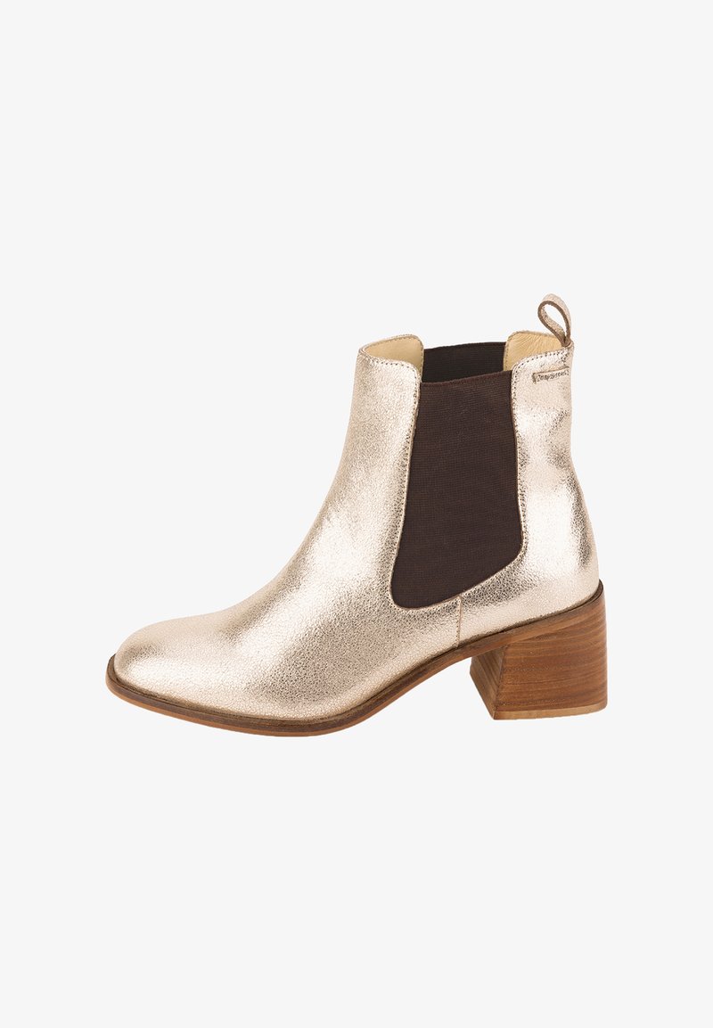 Botín metálico dorado con paneles laterales elásticos, punta redondeada y un tacón de bloque de madera de 5 cm. Presenta una textura suave y un brillo sutil.