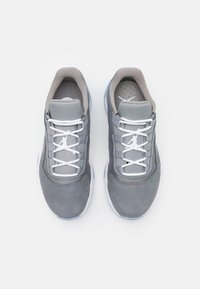 Szare trampki z gładkim zamszowym noskiem, siateczkowymi bokami, białymi sznurówkami i niebieskimi akcentami na teksturowanej podeszwie. Mają logo na języku.