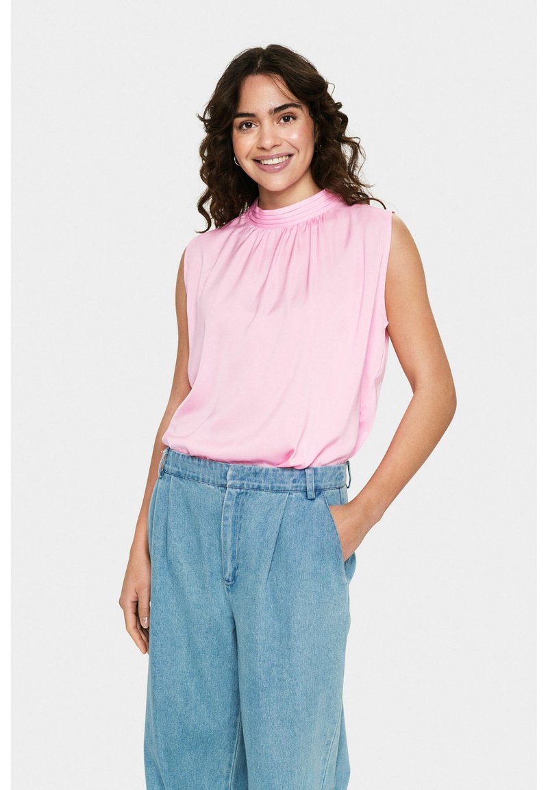Top senza maniche rosa con scollatura arricciata, abbinato a pantaloni in denim azzurri a vita alta. Tessuto morbido con vestibilità rilassata.