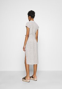 Kukallinen midimekko kevyestä kankaasta, jossa on lyhyet hihat, sidottu vyötärö, sivurei'ät ja herkkä kuvio pienistä monivärisistä kukista.