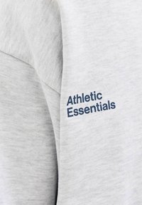 Sudadera de algodón gris con un logotipo azul de "Athletic Essentials" impreso en la manga, con una textura suave y un corte relajado.