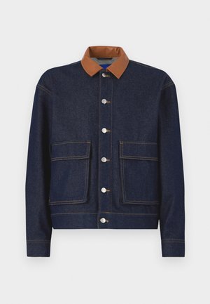 Jeansjakke med brun imitation skinnkrage, sølvfargede trykknapper og to framlommer. Mørkeblått stoff med kontrastsøm.