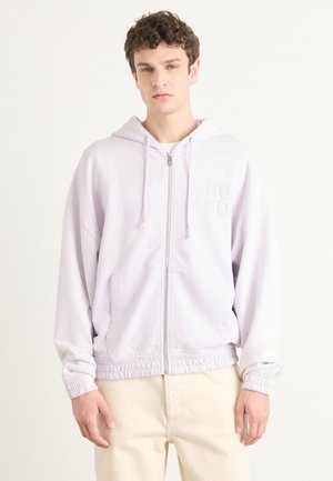 Lyse lavendel zip-hoodie med frontlommer, snørelukning i hætten og elastiske manchetter. Har et diskret broderet logo på brystet.
