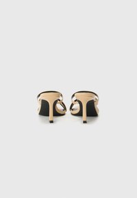 Sandali con tacco nudo con sottili cinturini neri e design elegante. Presentano una punta a punta e un tacco stiletto sottile.