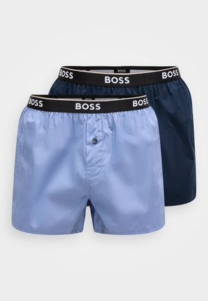 Two pairs of men's boxers: one light blue and one dark navy, both with elastic waistbands featuring "BOSS" logo. Soft, smooth fabric.