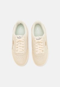 Sneakers in suede beige con chiusura con lacci, punta perforata e suola in gomma leggera. Logo del brand discreto e soletta imbottita per il comfort.