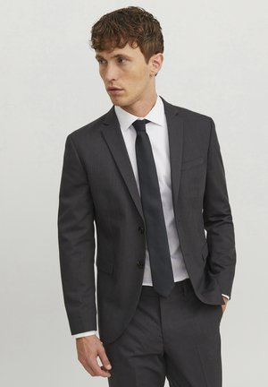 Dark gray suit jacket with two buttons, notch lapels, and single chest pocket; paired with a white shirt and black tie.