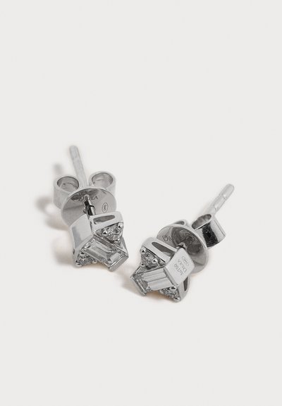 Paire de boucles d'oreilles clous en argent avec pierres précieuses rectangulaires transparentes et accents latéraux triangulaires sur un fond clair uni.