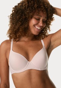 Reggiseno imbottito rosa chiaro con tessuto liscio, spalline regolabili e ferretto per supporto. Presenta un design senza cuciture e sottili dettagli di cucitura.