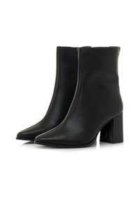Ein Paar schwarze Leder-Stiefeletten mit Blockabsätzen und seitlichen Reißverschlüssen, auf einem weißen Hintergrund präsentiert.