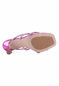 Zapatos de tacón alto fucsia de satén con correas plateadas entrecruzadas. Suela de goma texturizada en color beige con la marca "NINE WEST". Diseño de tacón elegante.