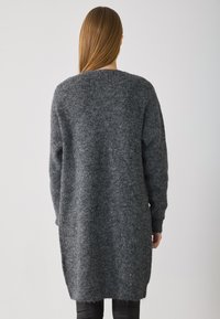 Grijze gebreide cardigan met een losse pasvorm, lange mouwen en een rond zoom. Textuurachtig wolachtig materiaal zorgt voor een zachte uitstraling.
