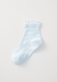 Gaiši zils potītes zeķes izgatavotas no mīksta auduma ar frillēm apakšā, ar balto Nike logo. Gluda tekstūra un noapaļota purngala forma.